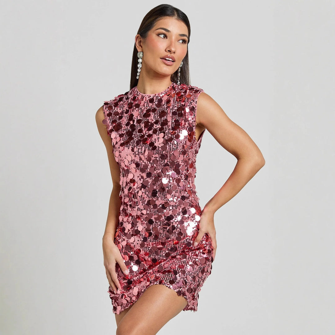 Woman wearing a pink sequin dress against a gray background